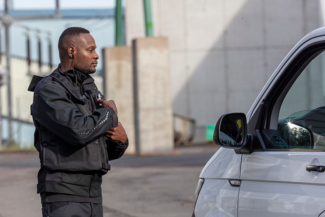 Security-guard-approaches-a-vehicle-640px-wide