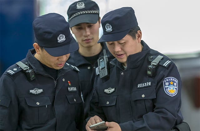 Police officer from Guangzhou China using a smartphone