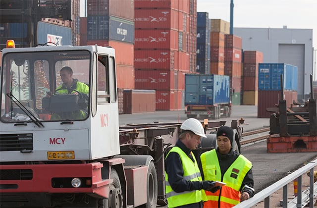 Two-workers-at-harbour-containers-in-the-background-640x420