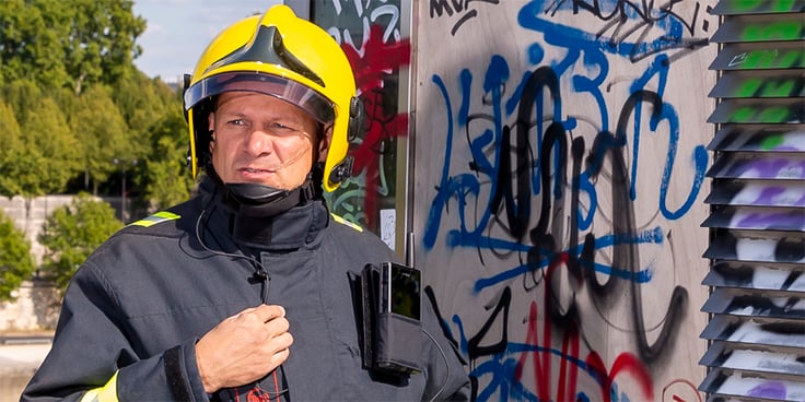 Firefighter carrying Tactilon Dabat in a carrying solution, graffiti on the background