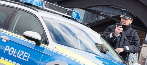 German-police-officer-behind-car_1000x447