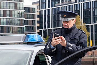 Police-standing-by-a-car-and-using-Tactilon-Dabat-339x229