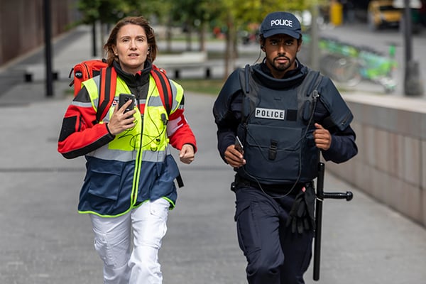 Medical professional with a smartphone and police, running