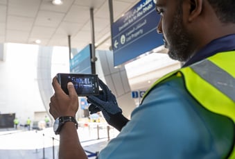 Airport trolley person holding a smartphone with video on screen